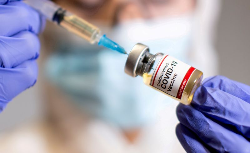 FILE PHOTO: A woman holds a medical syringe and a