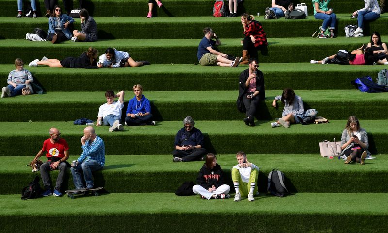 People are seen relaxing in an outdoor seating area, whilst