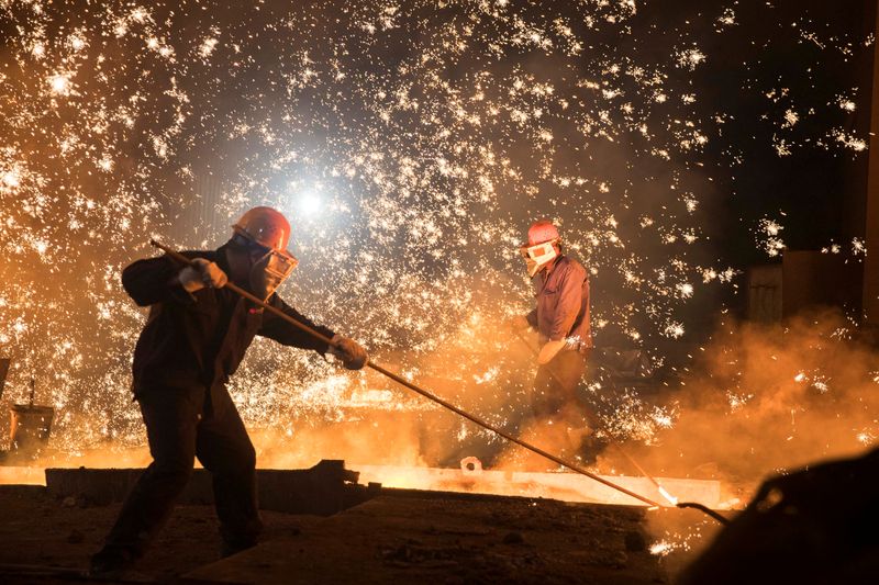 Laborers work at a steel plant of Shandong Iron &