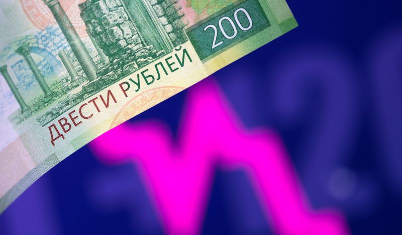 Illustration shows a Russian rouble banknote and a descending stock