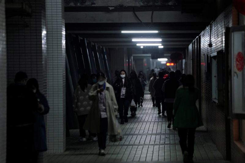 FILE PHOTO: Workers wearing masks are seen walking outside their