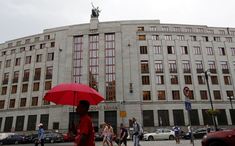 A man holds an umbrella in front of the Czech