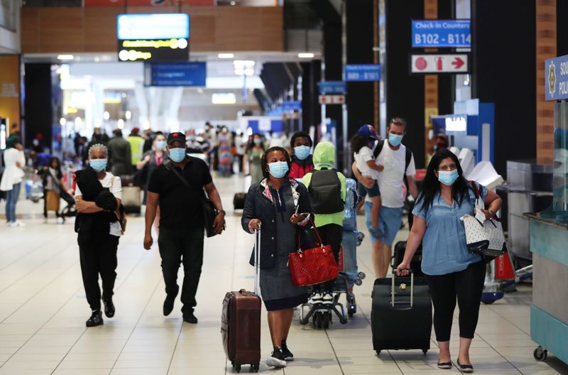 FILE PHOTO:  Passengers wearing protective masks walk to the