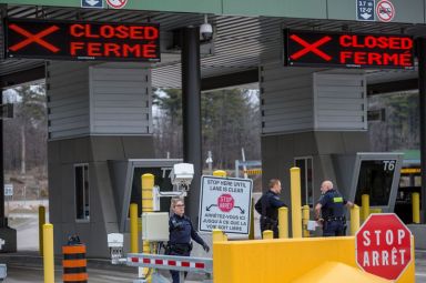 Canadian Border Services Agency officers stand in front of two